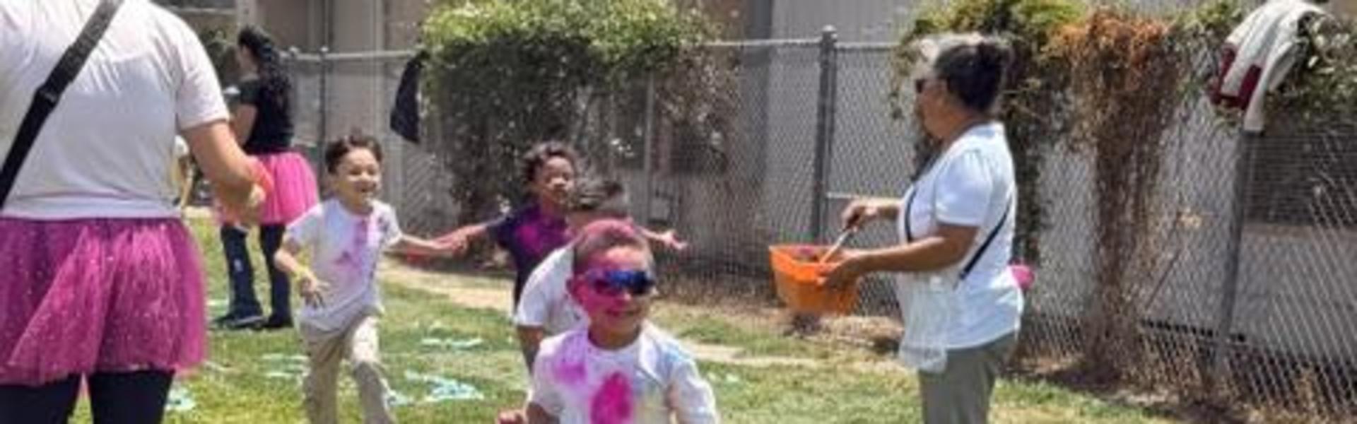 A child walks across grass with colorful streamers scattered around them.
