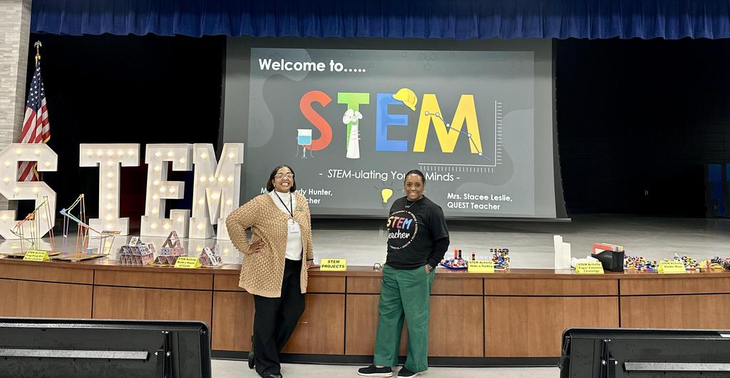 Teachers at STEM night in front of presentation