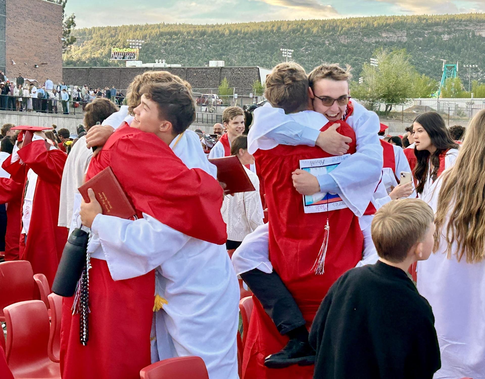 Two graduates hugging g
