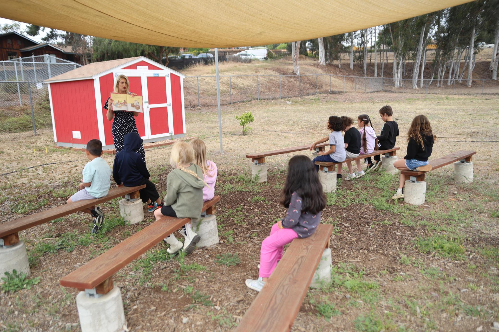 K-1 students reading time outside.