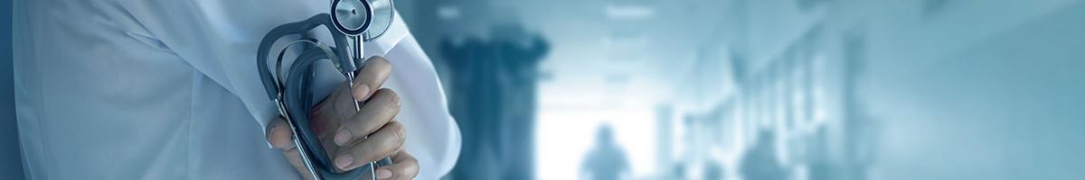 close up of doctor holding stethoscope in hallway