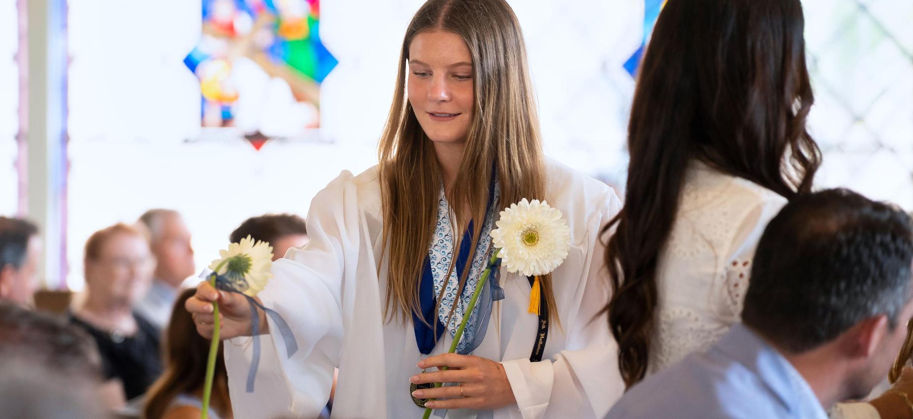 8th grade graduate presents flower to her mother as a thank you