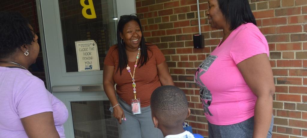 Principal greets family at schoolhouse door.