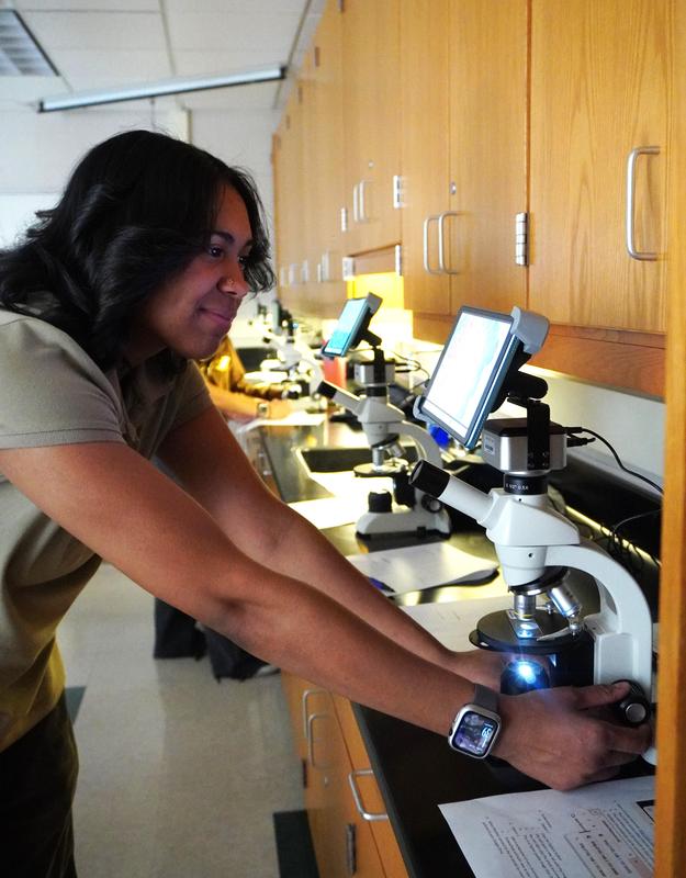 A student works with one of the new microscopes in a science class.