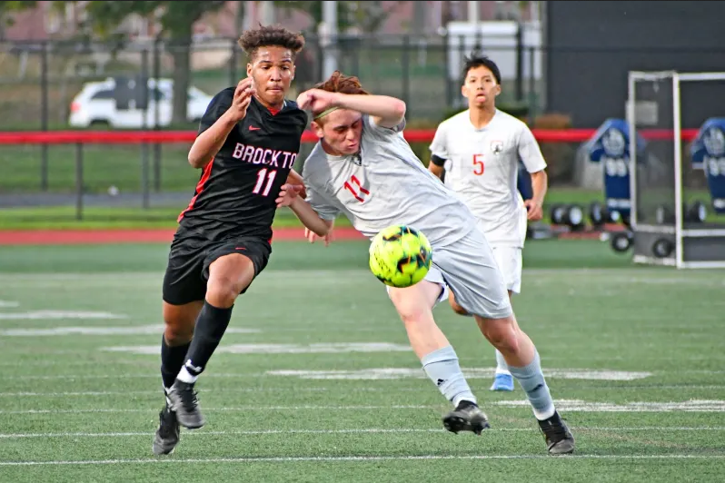 Boys soccer players chasing ball