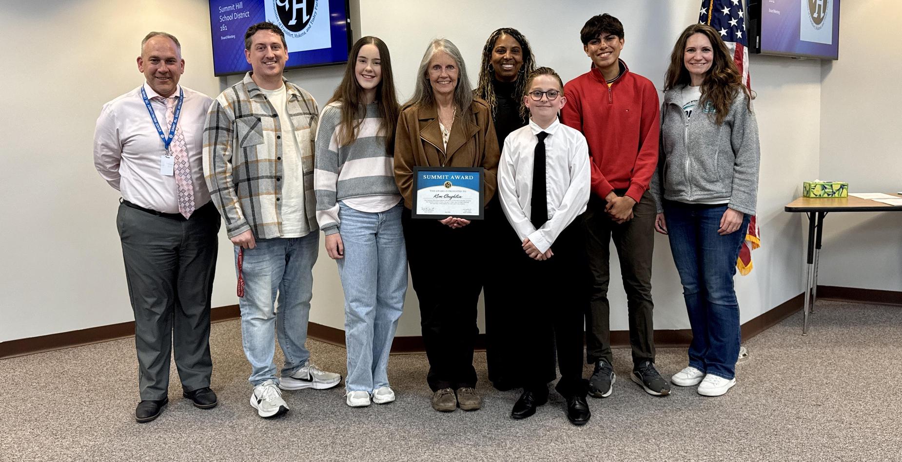 Group photo of May Summit Award winner Kim Coughlin with Summit Hill 161 staff and students after being recognized during the Board of Education meeting.
