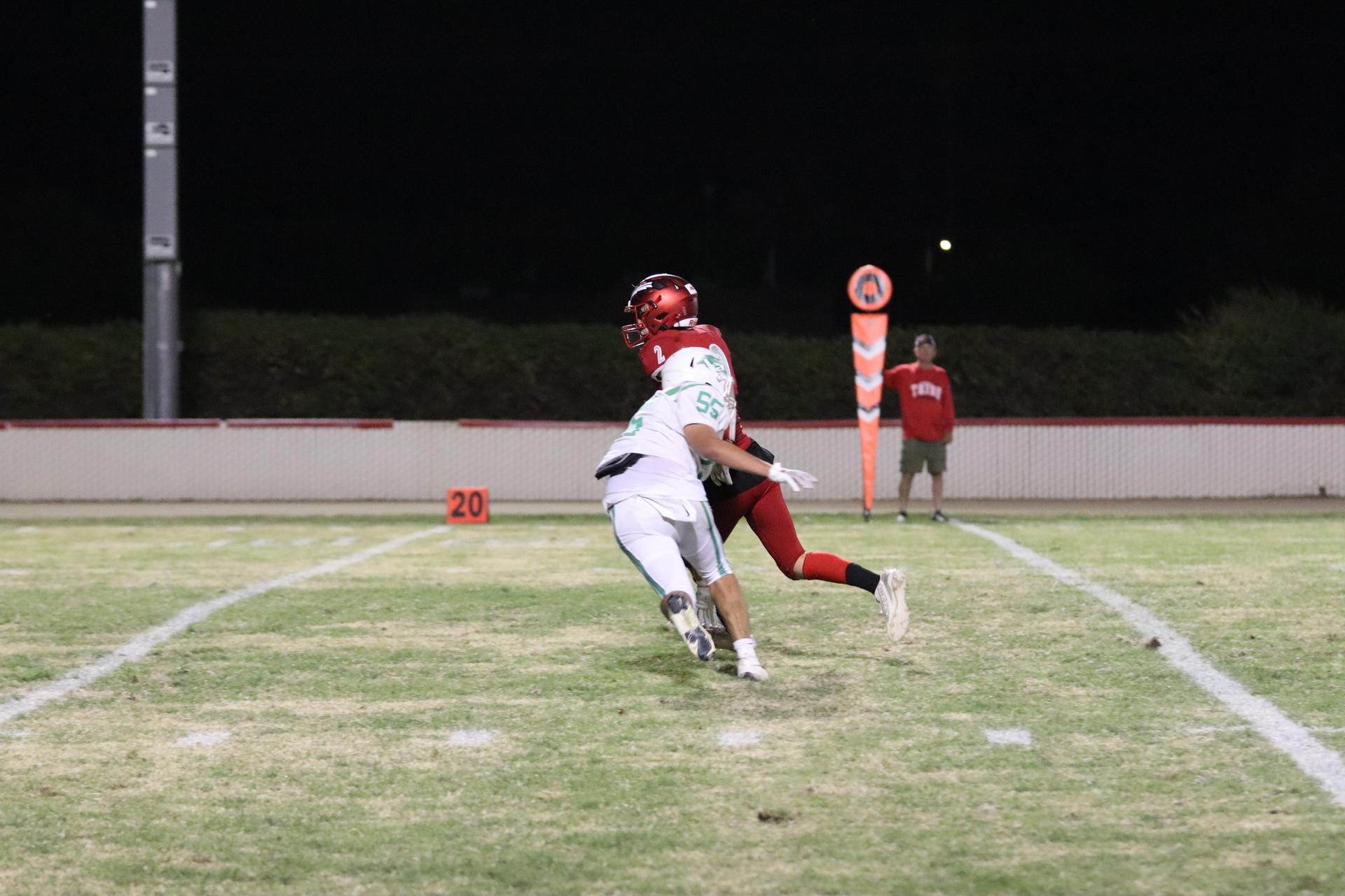 varsity football players in action against Riverdale