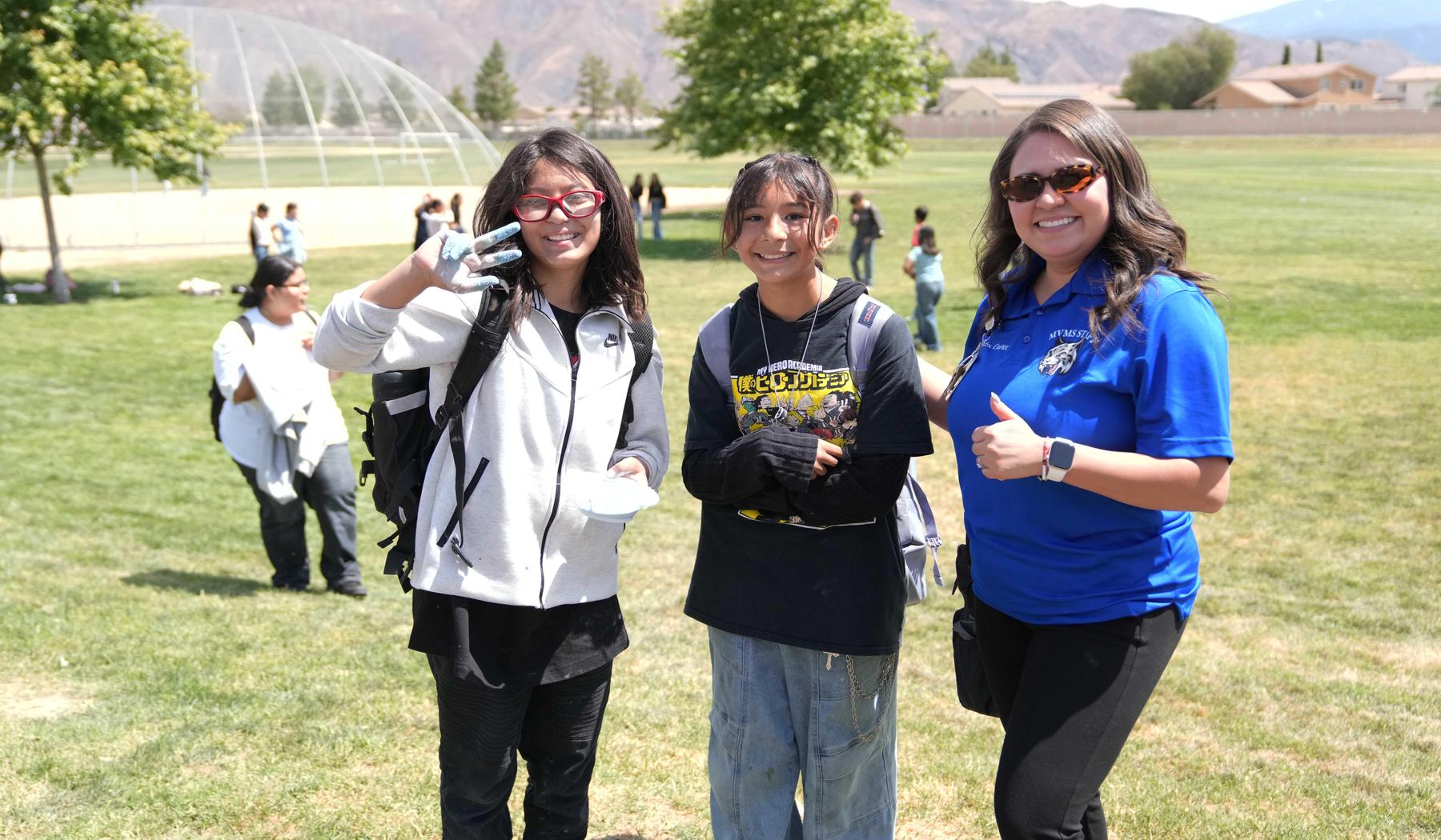 two middle school students with a teacher outside during a STEAM activity