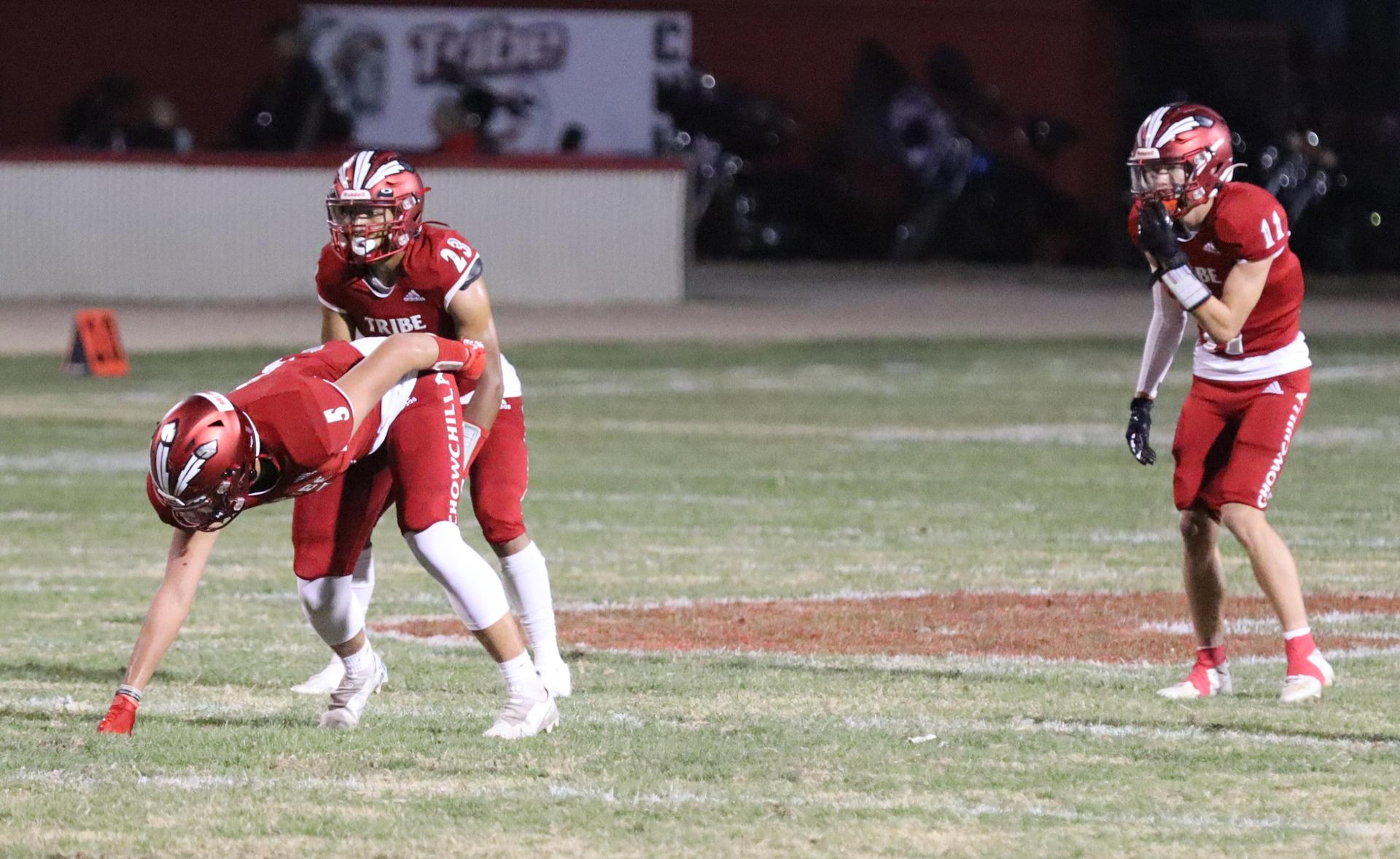 varsity football players in action against Riverdale