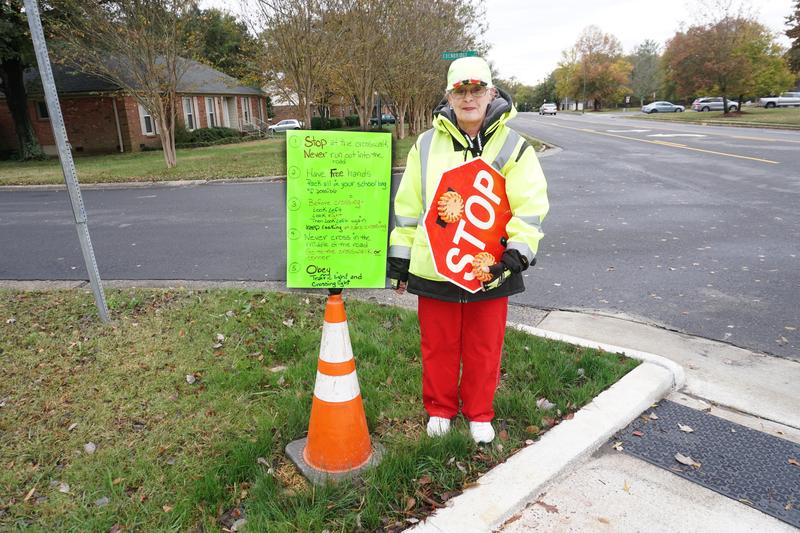 CMS crossing guard Sue Killar-Jordan in front of safety rule sign