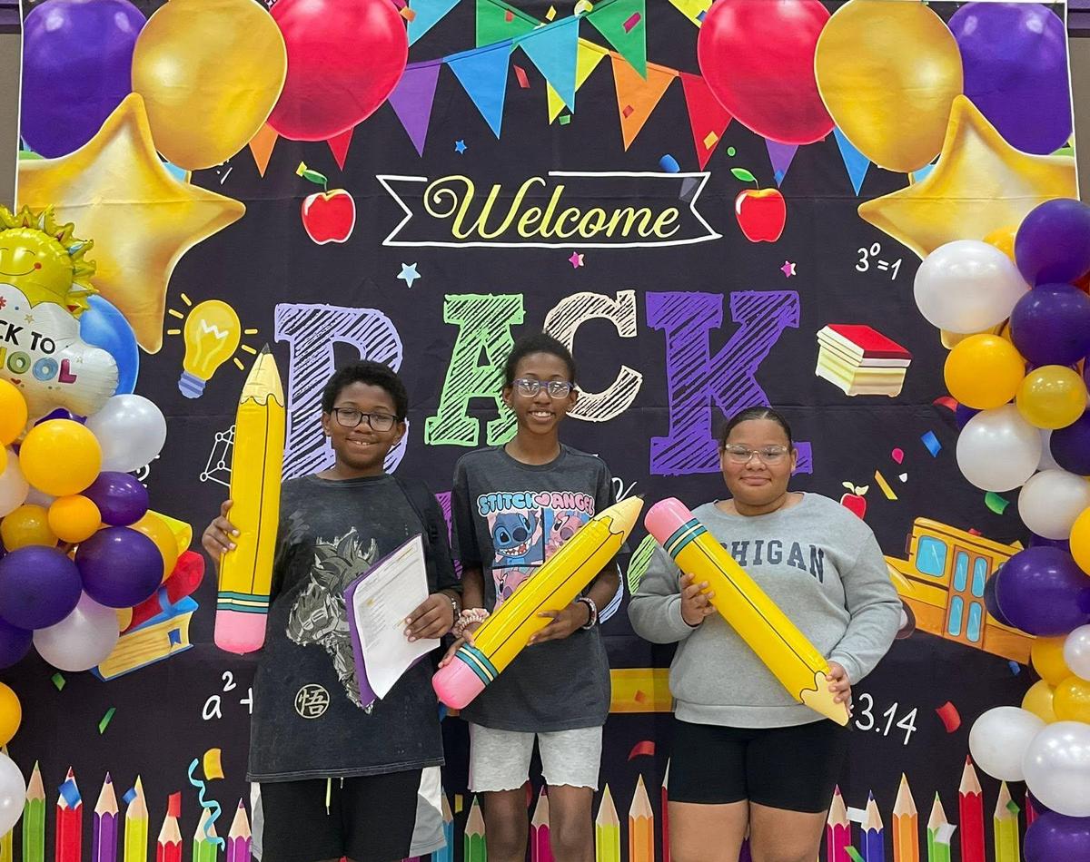 students pose for a photo in front of a back-to-school display at JIS