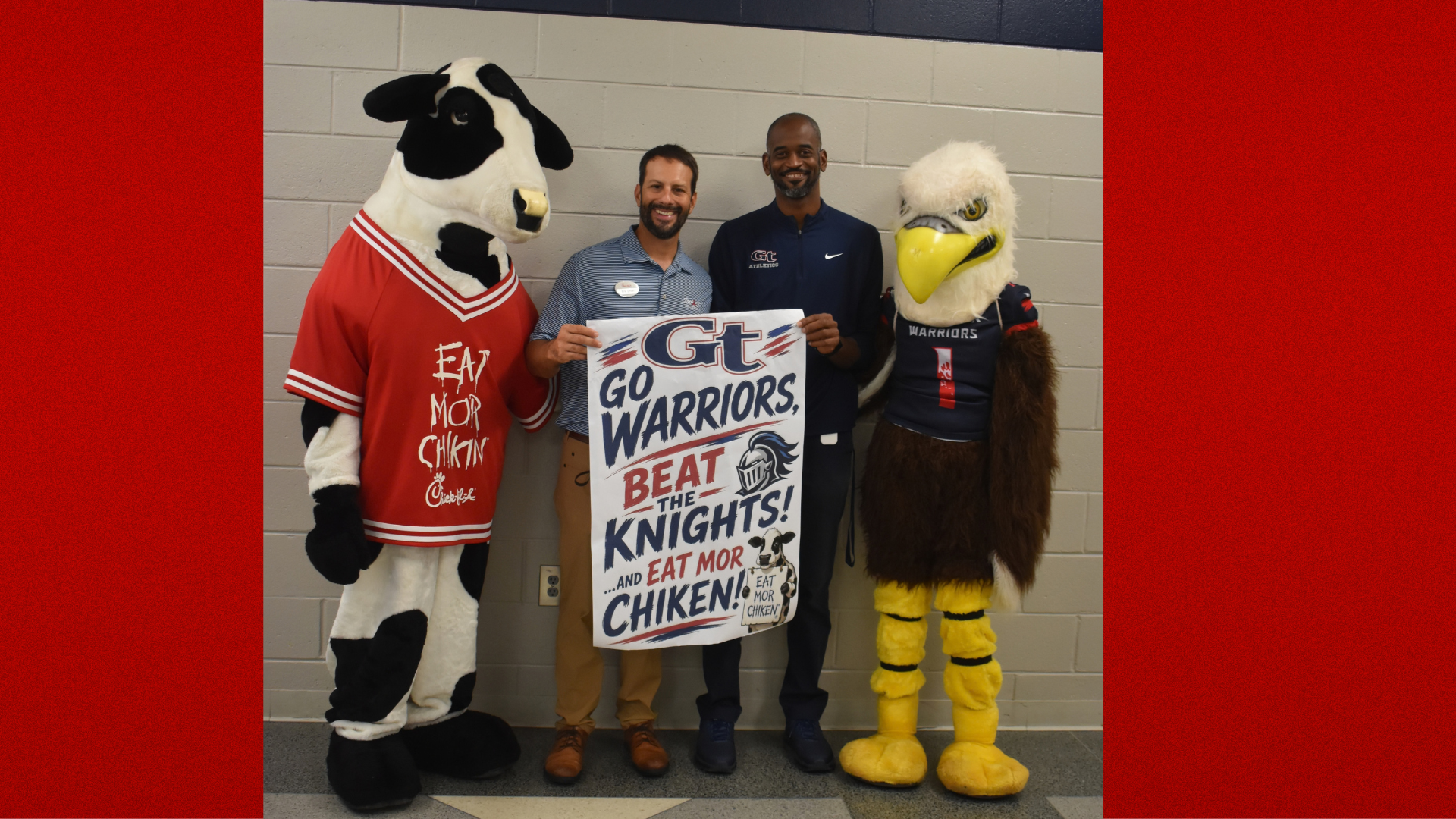Two mascots and a man holding a cheer sign in a school setting.