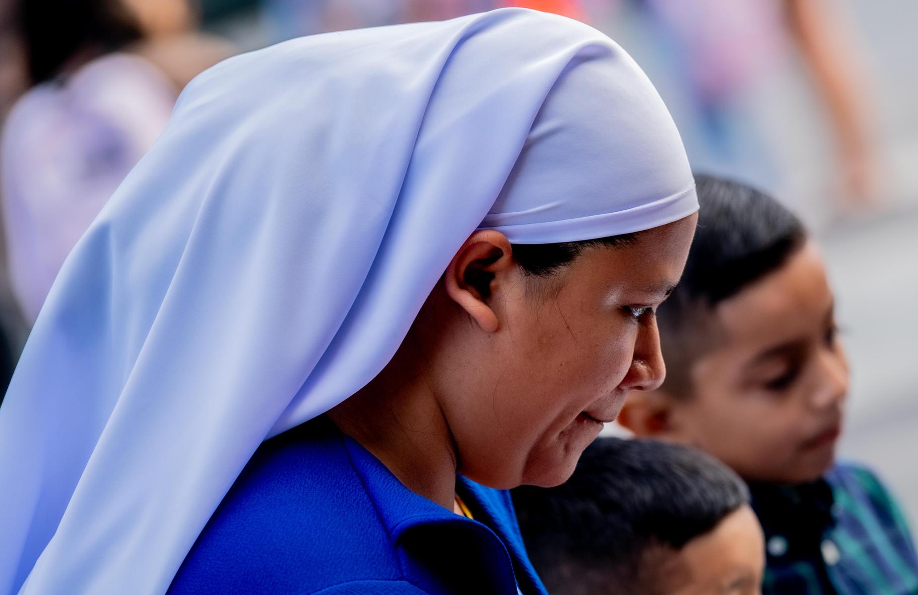Parent with a head covering listening to school staff