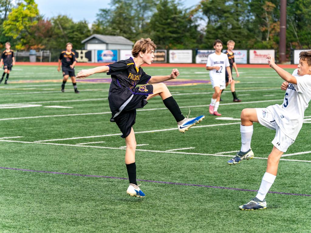 A soccer player mid kick on the field during a game.