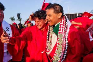 Two male seniors from Whittier High School smile and take a celebratory camera selfie together.