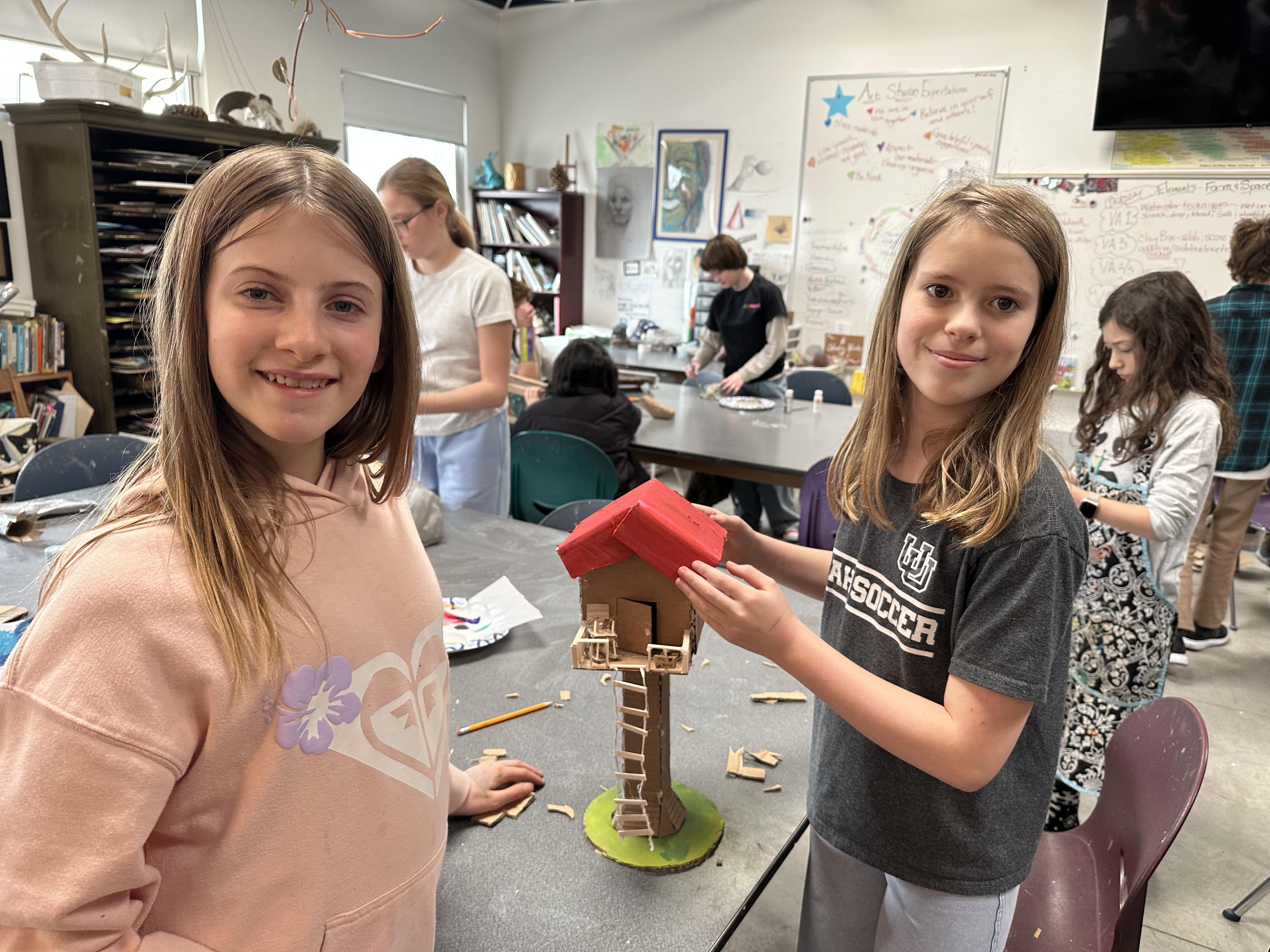 Two female student showing off artwork