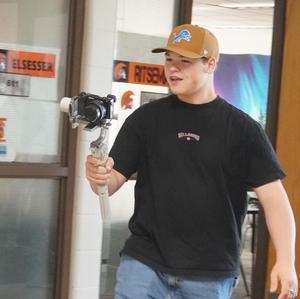 A student is using a stabilizer on a new camera to film.