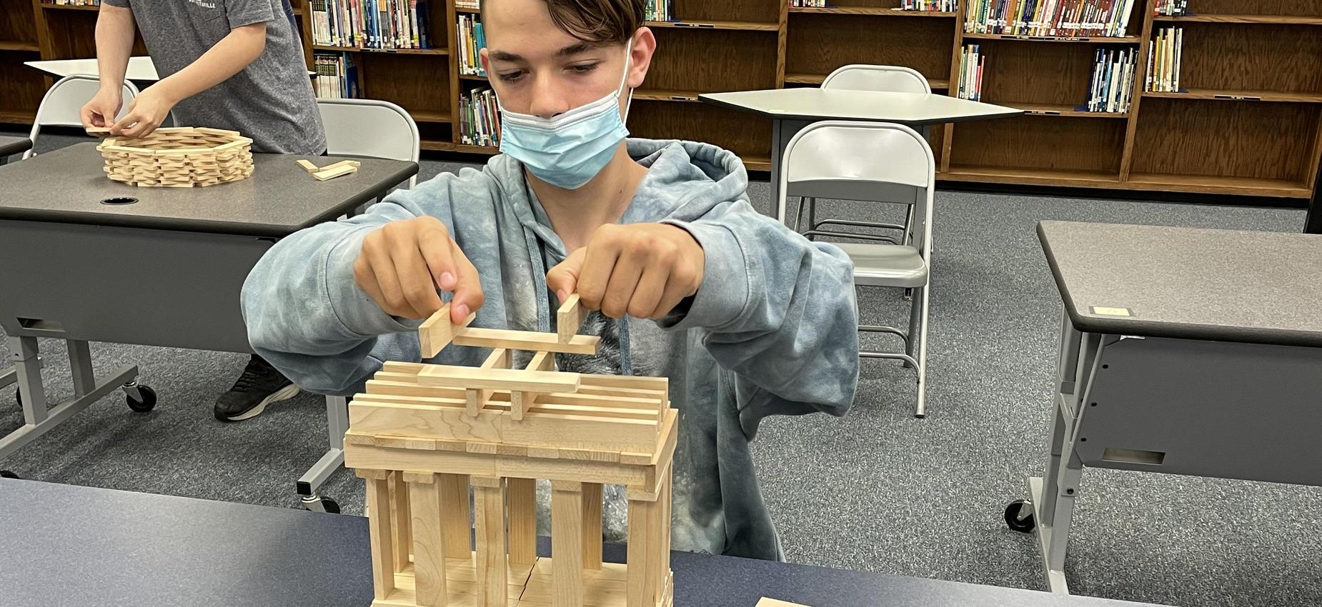 A student works with blocks in a library.