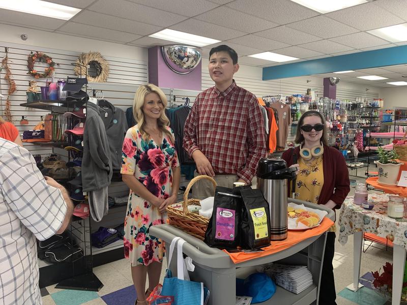 WPXI news reporter stands with WPSBC student and White Cane Coffee CEO at WPSBC's coffee cart