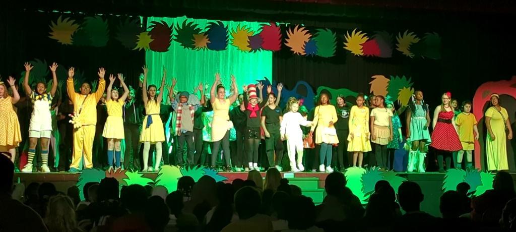 full cast on stage singing finale song