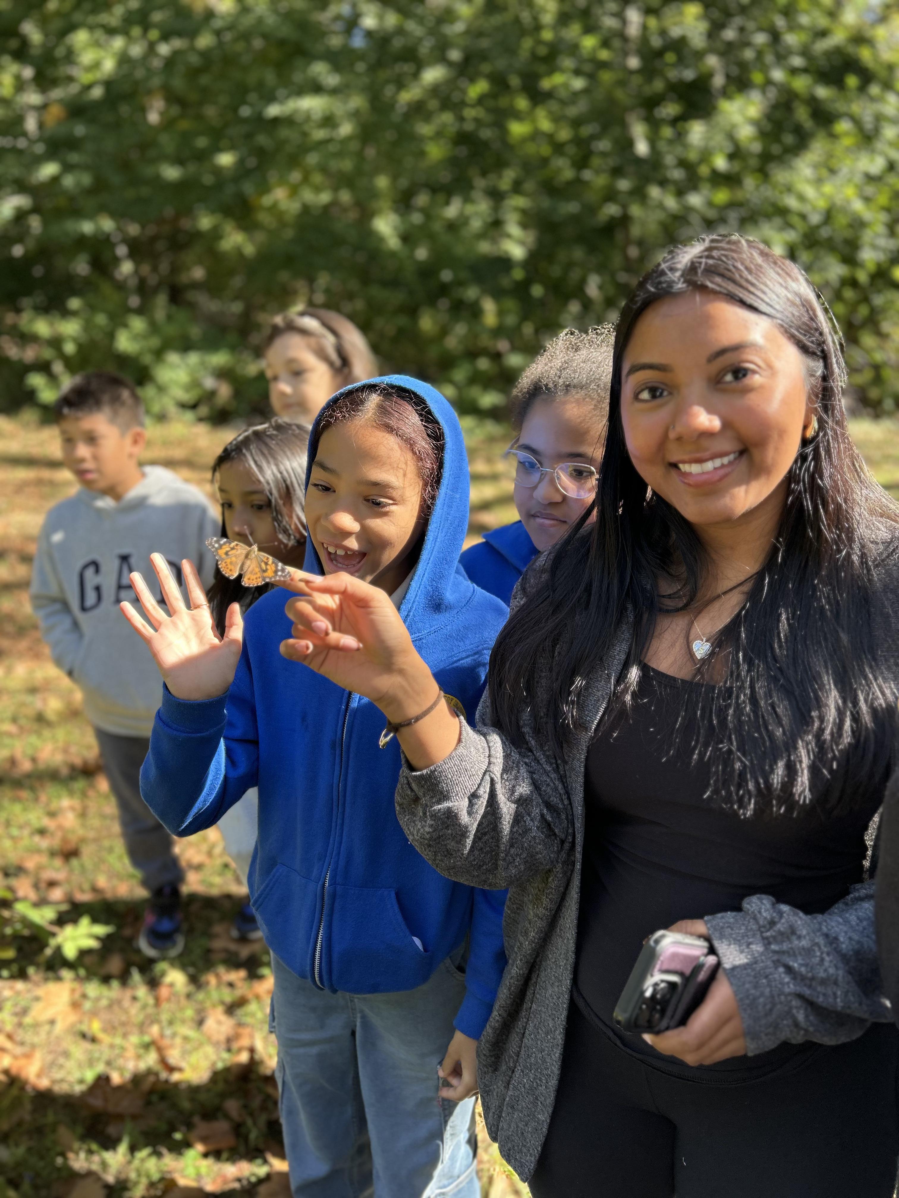 teacher holding butterfly with students