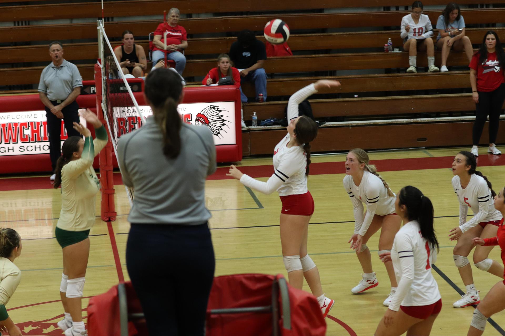 varsity volleyball players in action against liberty