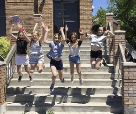 group of firls jumping from stairs outside