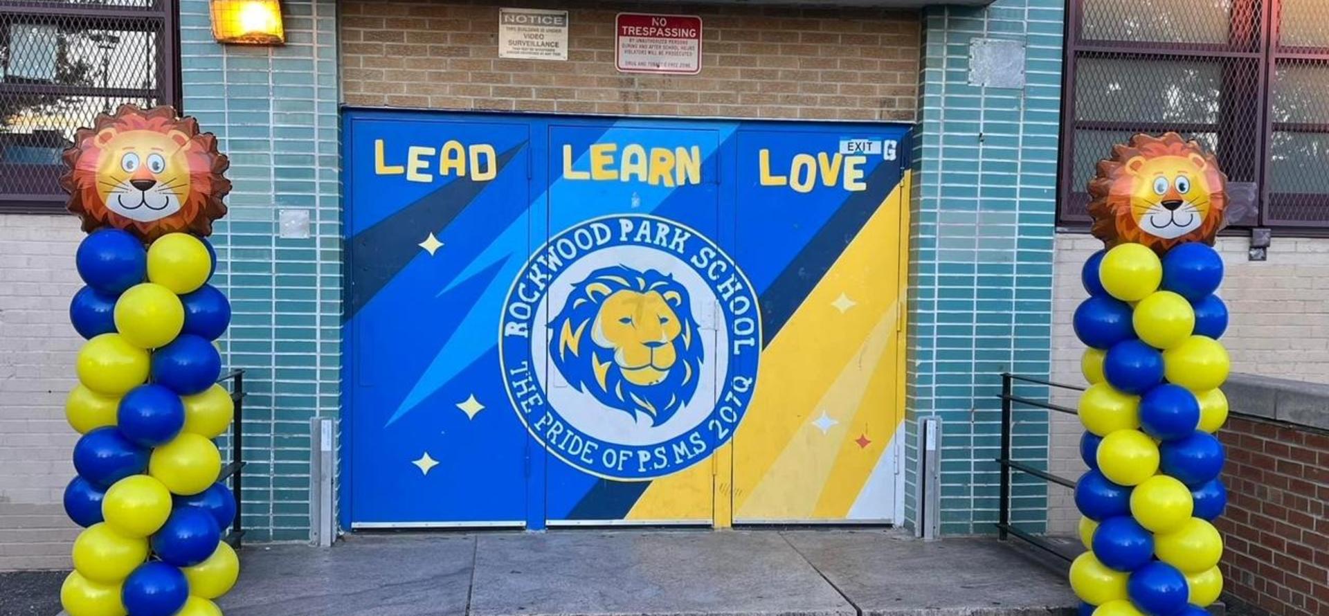 Colorful school entrance with lion-themed decorations and motivational words.
