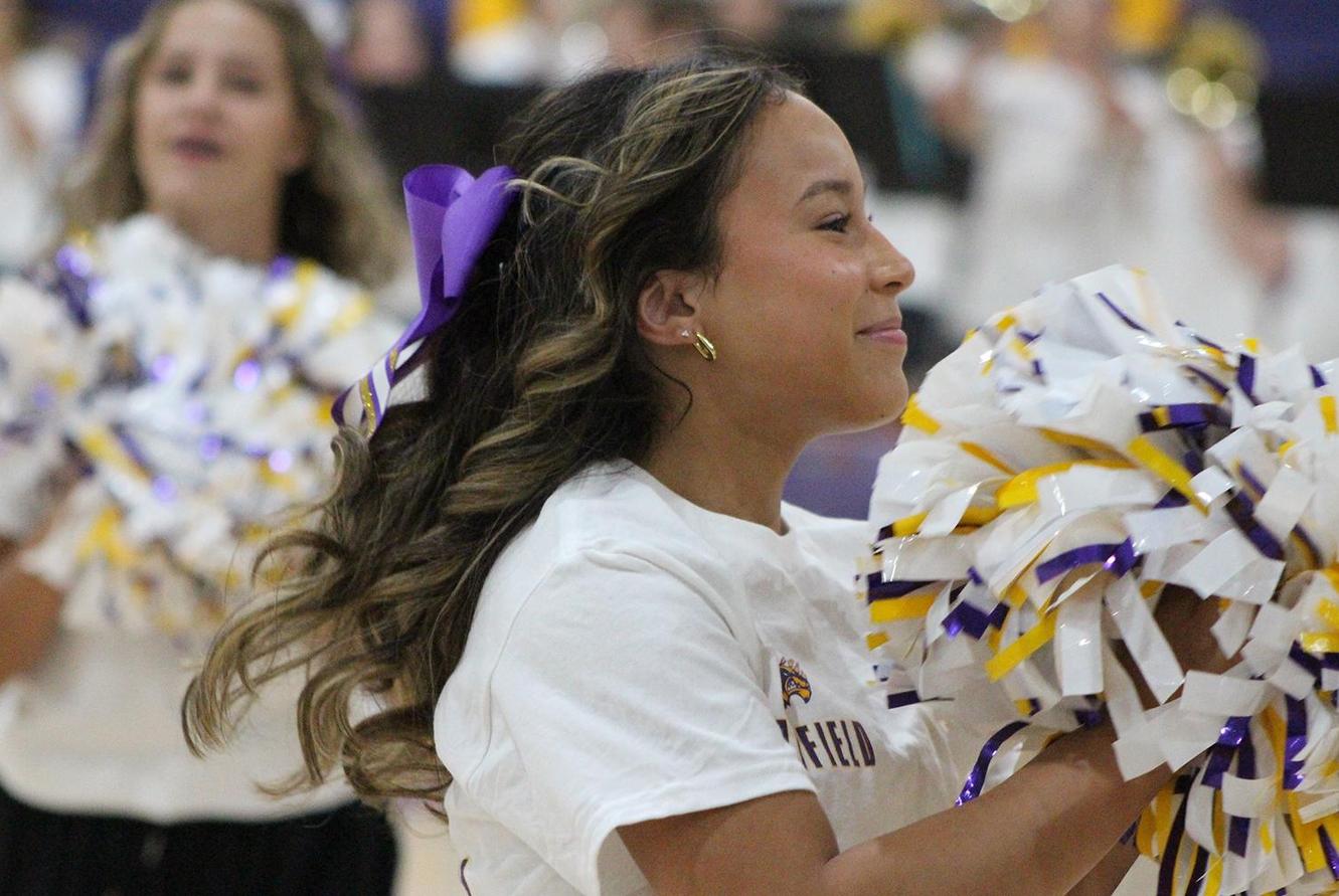 A smiling cheerleader with pom poms