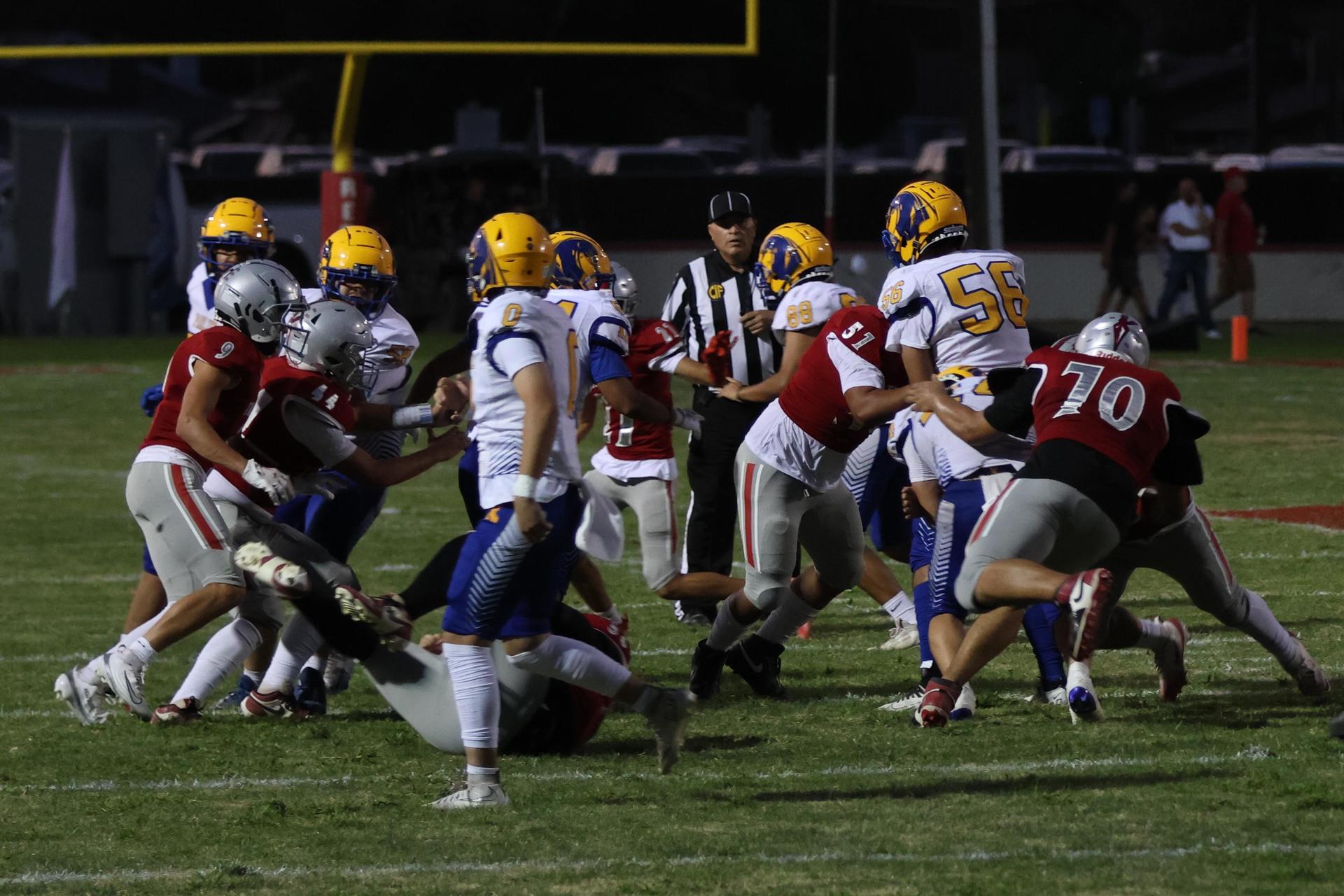 Varsity football players in action against Parlier 9