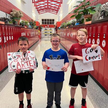Three enthusiastic youth students cheering on their peers.