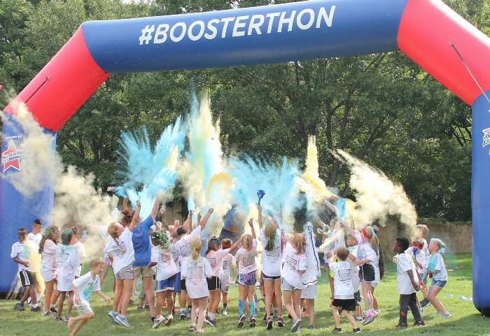 Image of children running through a finish line with colored powder.