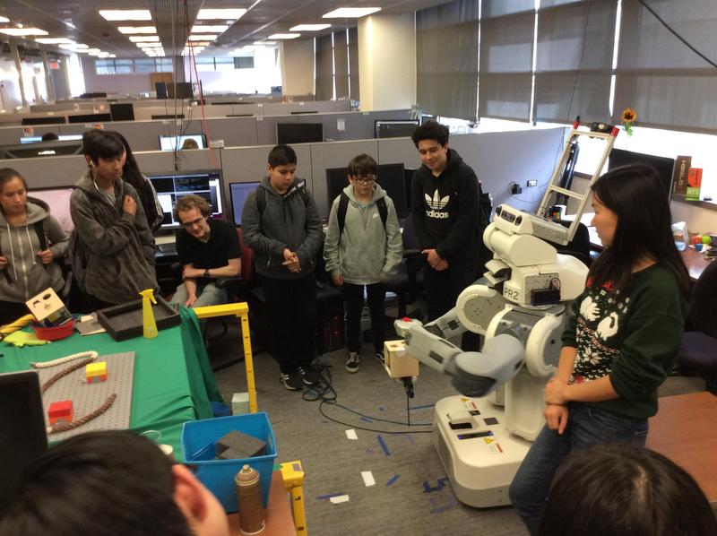 Bridges Academy middle school students and a Berkeley research student standing next to a human-size robot