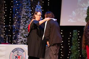 Graduate receiving their stole from their teacher