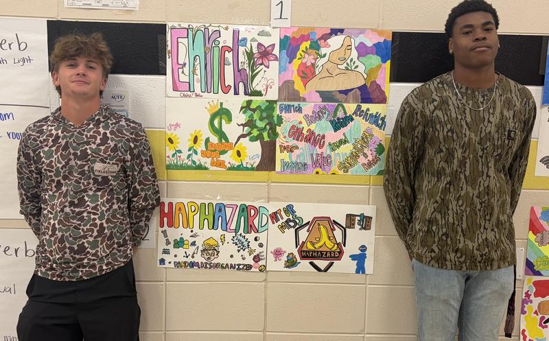 Two boys stand beside their vocabulary word art