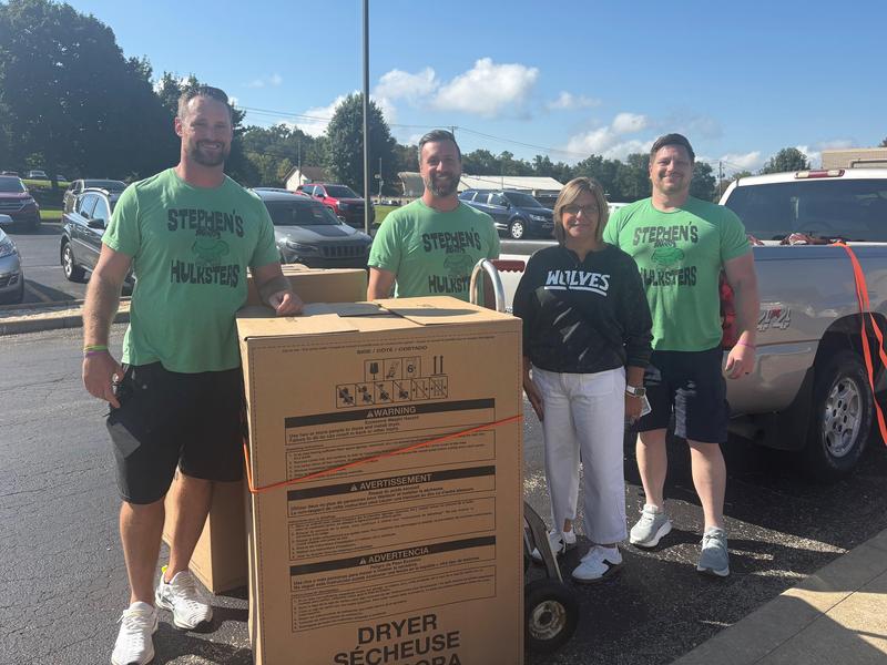 A group from Stephen's Hulksters delivers a washer and dryer to Clairview School. Luann Murtha receives the donation.
