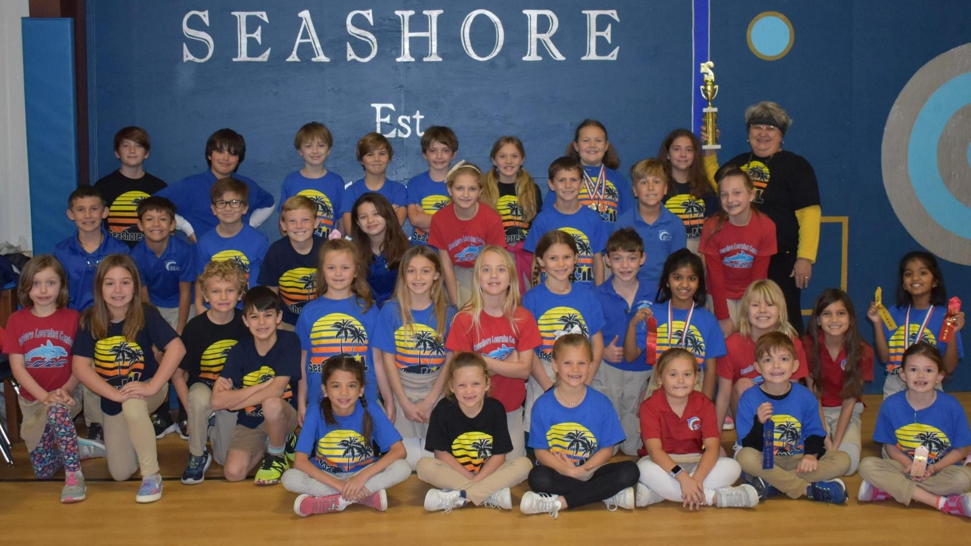 Group of children in colorful shirts posing together at a school event.