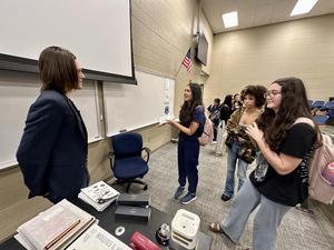 Man stands before students in crowded room