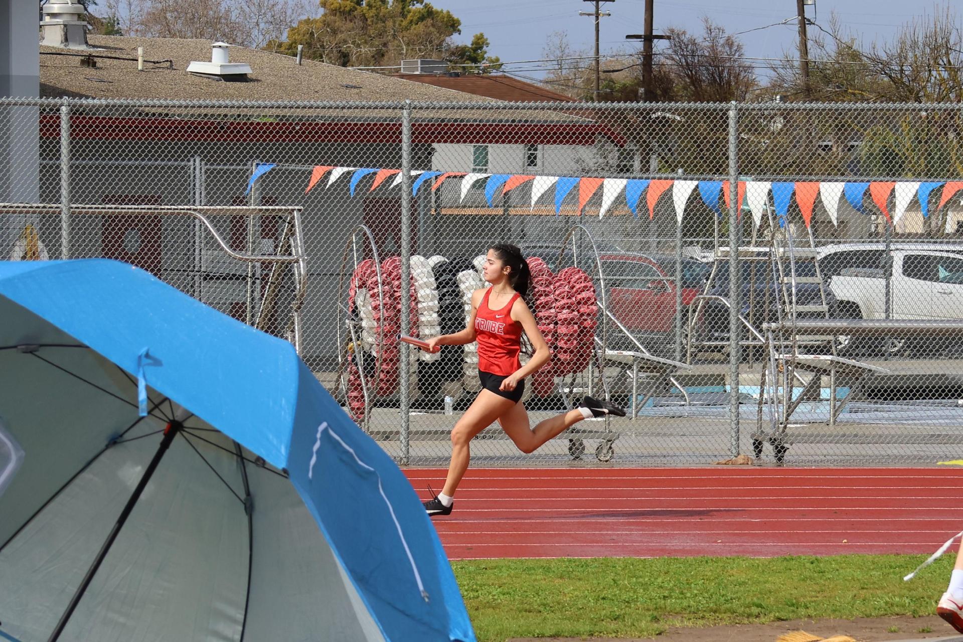 girls running the four by 100 meter relay