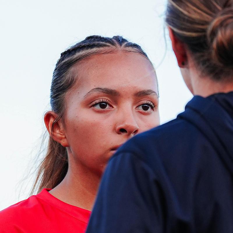 Closecrop view over someone's left shoulder and into the face of a player
