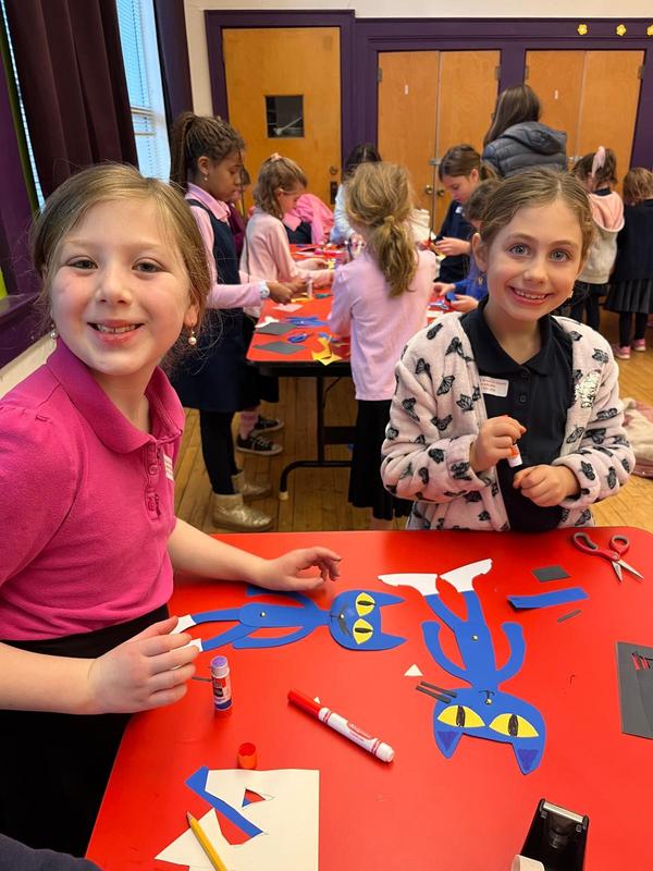 Two students working on a paper puppet.
