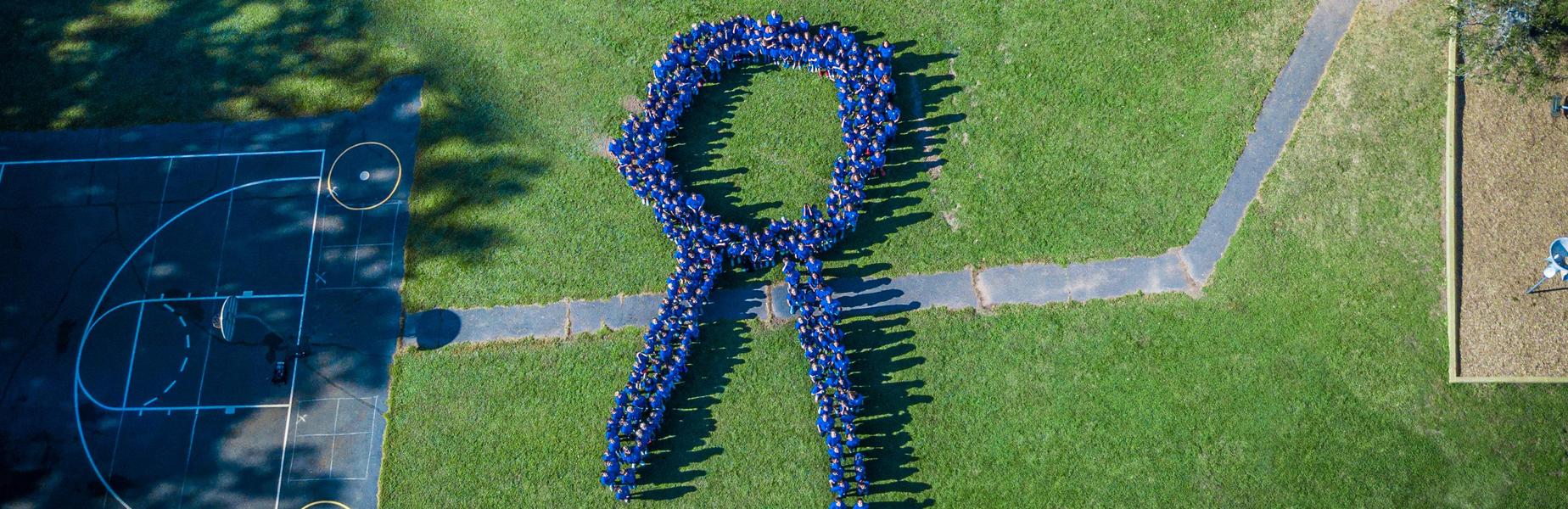 Aerial photo of Washington staff in blue shirts positioned in shape of a blue ribbon to celebrate designation as National Blue Ribbon School.