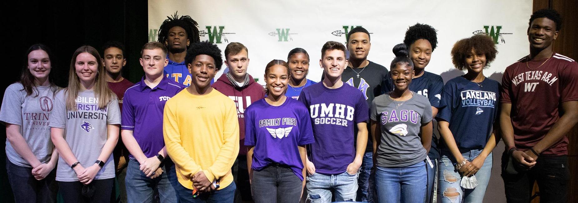 group of teen athletes on the stage at the signing day ceremony