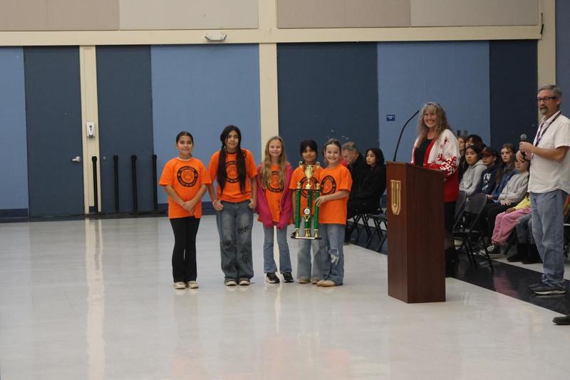 Students holding attendance trophy