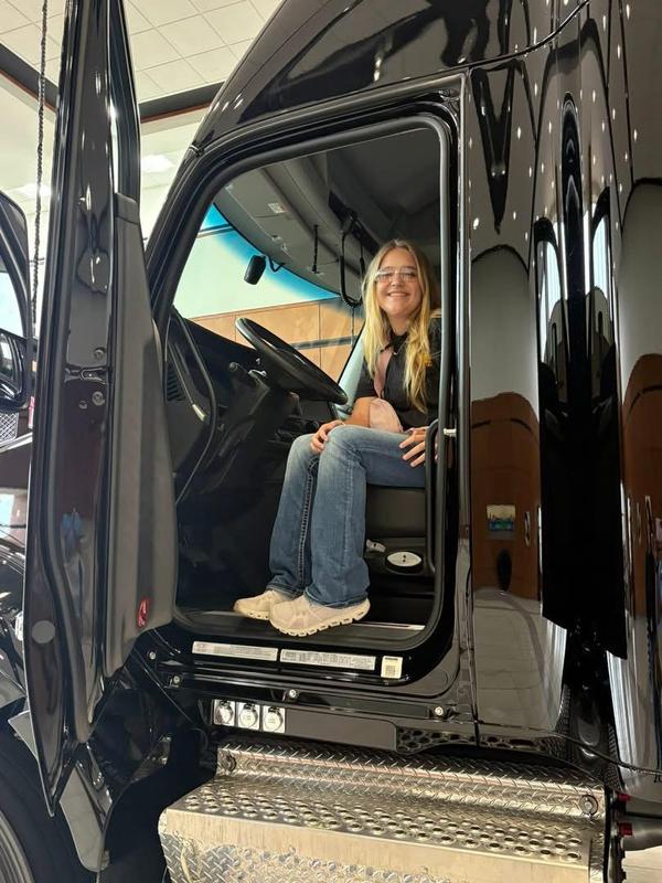 Ellie sitting in the cab of a big truck