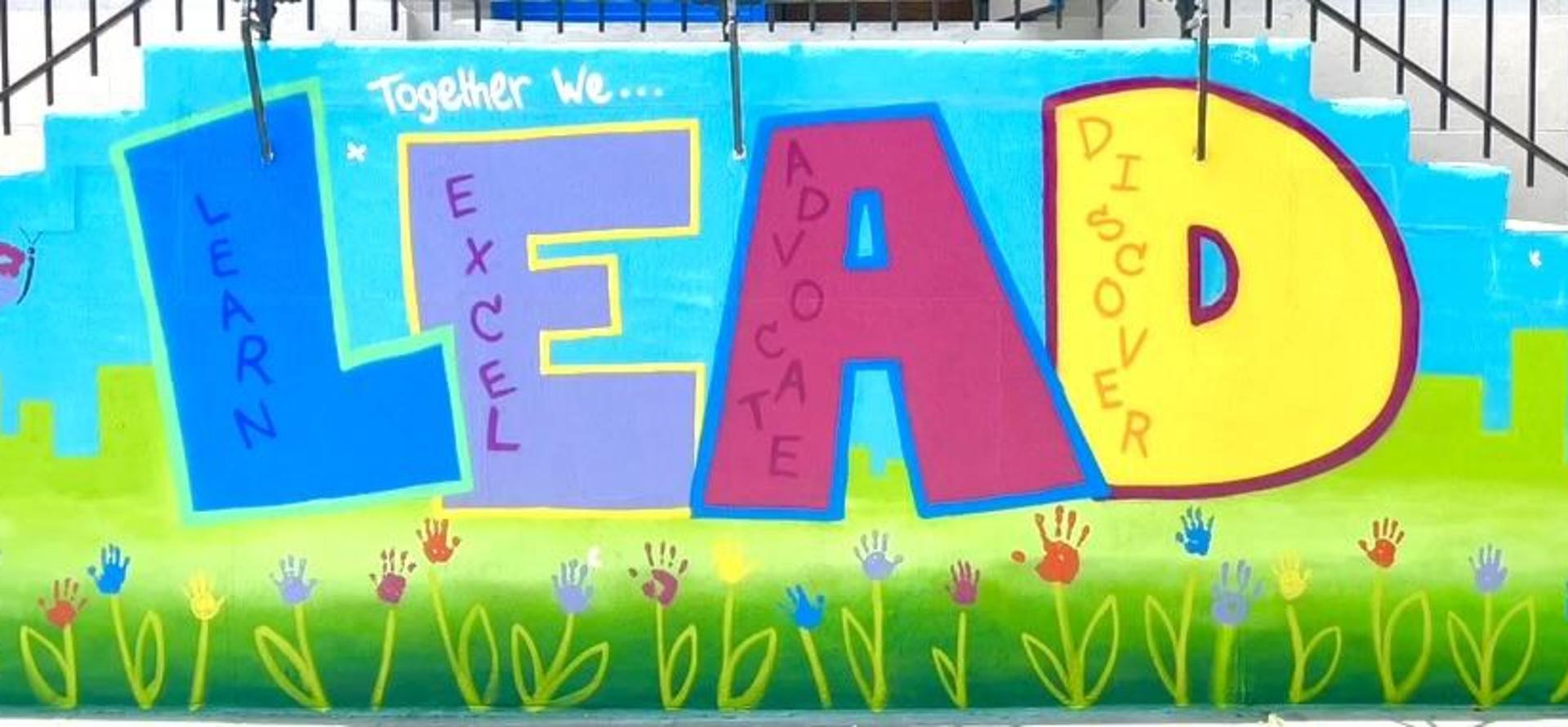 Colorful mural featuring the words 'LEAD' and 'Learn, Excel, Advocate, Discover' with flowers.