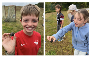 two students holding a baby snapping turtle