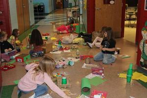 students are sitting in hallway and hallway in covered in craft supplies