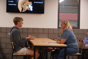 A TKHS teacher talks with her student athlete in the cafeteria.