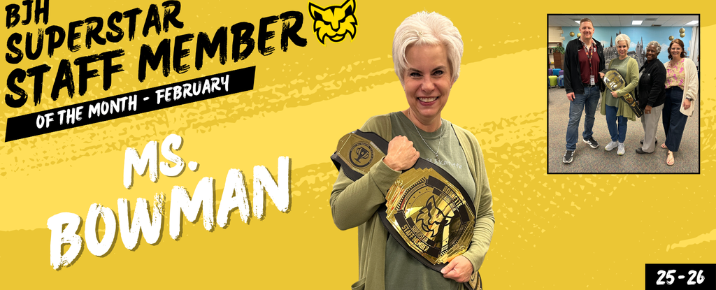 A smiling woman holds a championship belt, celebrating as Staff Member of the Month.